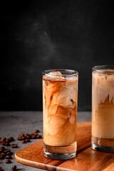 Ice coffee in a glass with cream poured over.