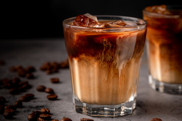 Ice coffee in a glass with cream poured over.