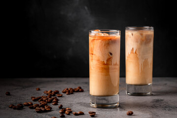 Ice coffee in a glass with cream poured over.