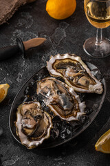 Fresh oysters close-up on ice served with lemon and wine.