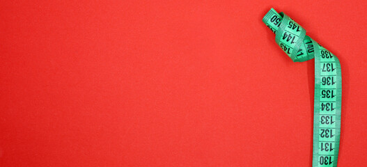 Fototapeta premium green tape measure on red background