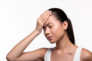 Unhappy millennial chinese lady touching her forehead