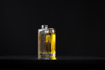 Botella de vidrio de aceite de oliva virgen extra premium. Aislado sobre fondo negro - obrazy, fototapety, plakaty