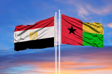 Egypt and Guinea Bissau two flags on flagpoles and blue cloudy sky