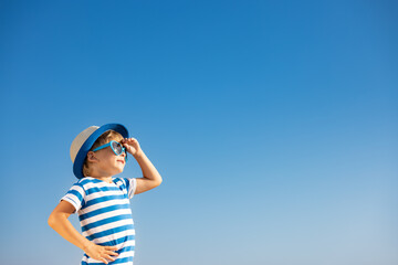 Happy child having fun outdoor against blue sky