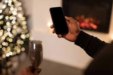 Unrecognizable Guy Holding Cellphone With Empty Screen Celebrating Christmas Indoor
