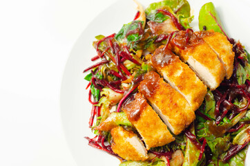 Breaded crispy chicken breast fillet with mixed salad and grated beetroot