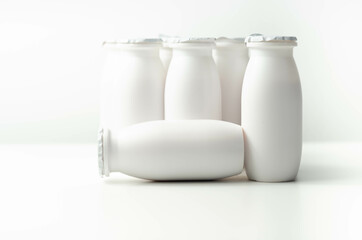 White plastic yogurt bottles on white background, typical packaging for dairy products