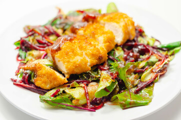 Breaded crispy chicken breast fillet with mixed salad and grated beetroot