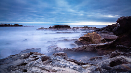 Fototapeta na wymiar Rocky Coast with Blurry Waves