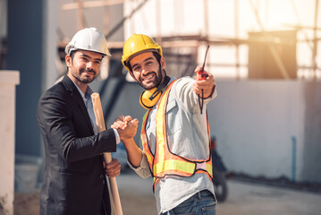Happy workers at construction site, young civil engineer manager and architects handshaking at...