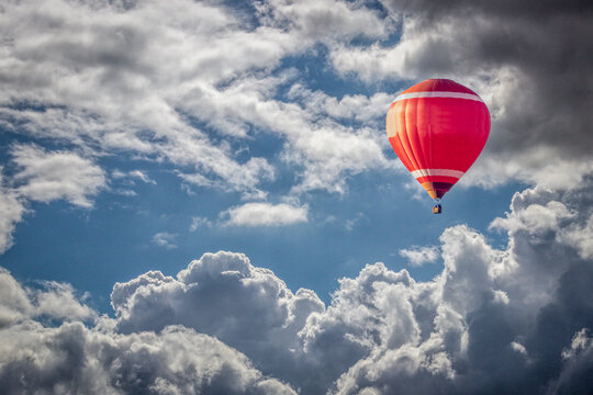 a red hotair balloon soaring through the clouds