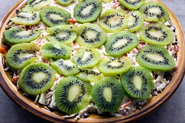 Fruit salad with kiwi in a dish. Horizontal framing