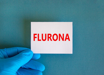 Covid-19 corona and flu flurona symbol. Hand in blue glove with white card. The concept word...