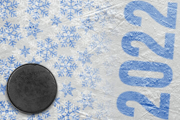 A fragment of an ice arena with a winter pattern and a hockey puck