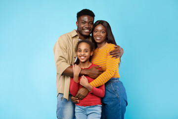 Fototapeta premium African American man hugging his wife and smiling daughter