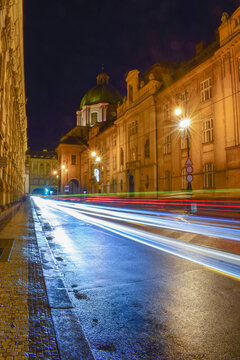 Blurred traffic in night street, buildings and church dome