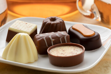 Variation of delicious chocolate bonbon on a white plate close up 
