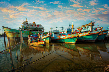 Fototapeta na wymiar Fishing port and beautiful sky in Asia,Many boats moored in sunrise morning time at Chalong port, Main port for travel ship to krabi and phi phi island, Phuket, Thailand
