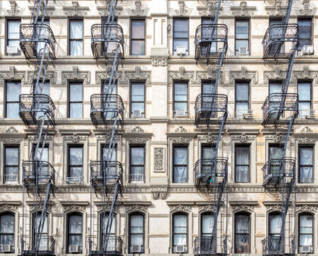 Exterior view of historic apartment buildings in the Lower East Side of New York City with windows and fire escapes