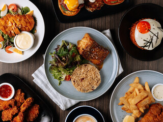 A breakfast fast food table Pan Fried Wild Cod Fish, Kimchi Fried Rice, Wing Zing, Fish And Chips, Caramel Latte, Eggs Blackstone, top view food