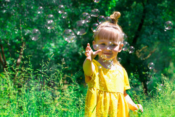 Little girl blows soap bubbles