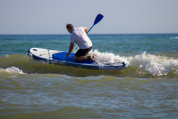 Wellenreiten mit einem surfbrett - (stand up paddle), im meer bei hohen wellen. 