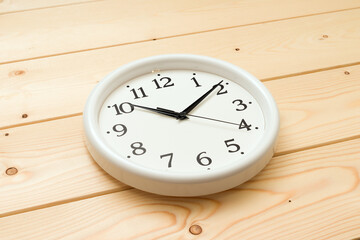 round wall clock lie on a wooden background