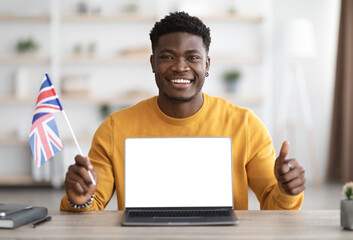 Positive african american man showing flag of UK and laptop