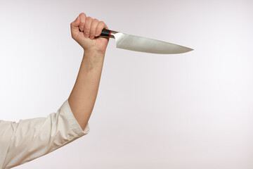 sharp kitchen knife in a female hand close-up on a white background