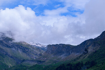 The mountains of the countryside around the Roselend dam in Europe, France, the Alps, towards Beaufort, the Alps, in the summer on a cloudy day.