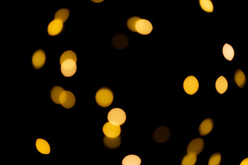 black background with golden glittering lights bokeh. abstract defocused pattern