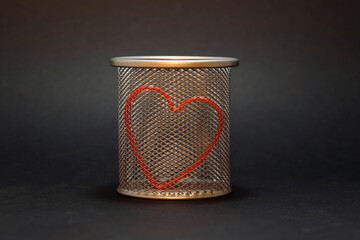 Container with a red heart. Isolated on a black background. 