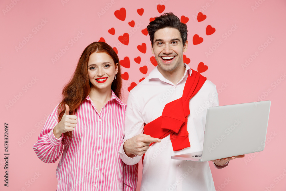 Sticker Young couple two friends woman man in casual shirt hold use work on laptop pc computer show thumb up isolated on plain pastel pink background studio. Valentine's Day birthday holiday party concept