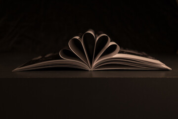 Aufgeklapptes Buch auf schwarzem Hintergrund