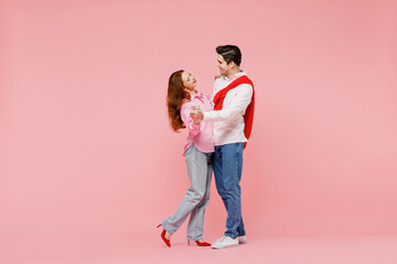 Full body side view happy young couple two friends woman man 20s in shirt hold hands dancing...