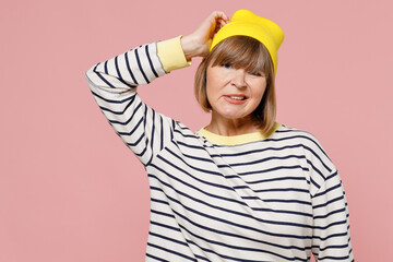 Elderly confused puzzled sad stylish woman 50s wearing striped shirt yellow hat look camera scratch...