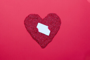 White card in shiny red heart on red background