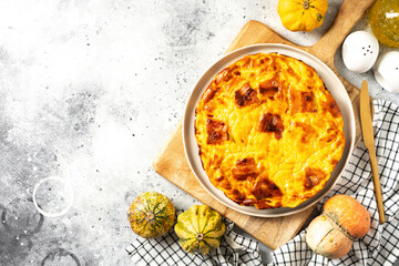 A piece of frittata with pumpkin, bacon and ricotta in a ceramic plate on a light culinary background. Traditional Italian delicious homemade egg dish on the kitchen table top view	