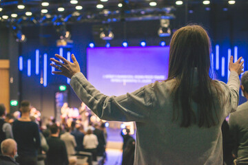 Hands in the air of a woman who praise God at church service - 478373620