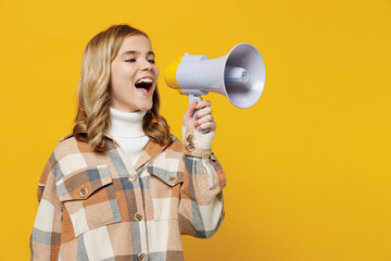 Little blonde caucasian kid girl 13-14 years in checkered shirt hold scream in megaphone announces discounts sale Hurry up isolated on plain yellow background studio portrait People lifestyle concept