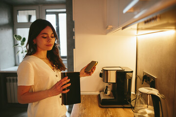 Fototapeta na wymiar Young woman making morning coffee in the kitchen.