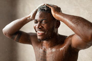 African Guy Washing Hair With Shampoo Taking Shower In Bathroom
