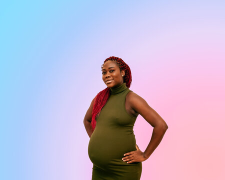 black pregnan woman wearing a green dress on a colorful background