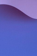 Abstrakte Welle aus pastellblauem, violettem, sehr perifarbigem Papier. Kreatives geometrisches gebogenes Papier mit Licht und Schatten. Vertikaler Hintergrund der abstrakten Geometrie mit Kopienraum