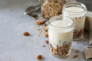 Healthy breakfast, yogurt parfait. Yogurt with homemade almond granola on a gray concrete background. Copy space.
