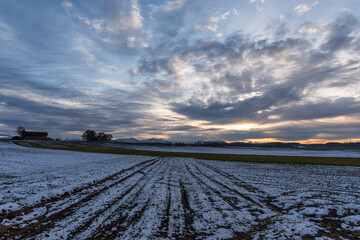 Ackerfurchen mit Schnee vor Alpen Panoramaim Chiemgau, 