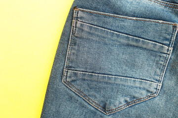 Back pockets of blue jeans on yellow background