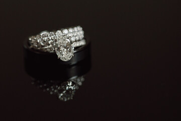 Large Diamond Engagement Ring with Wedding Bands on Dark Reflective Background