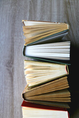Bunch of vintage hardcover books on wooden background. Top view.